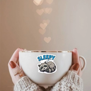 Détail d'un autocollant de raton laveur mignon sur un mug en céramique blanche avec bord doré