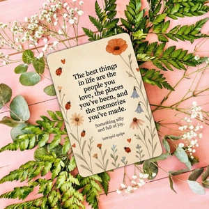 Nahaufnahme der Motivationskarte mit Blumen-Illustrationen auf rosa Holzhintergrund