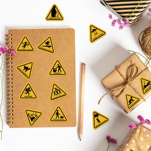 Detail of yellow warning stickers with funny icons on a craft notebook and gift box