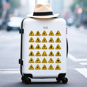 Close-up of funny yellow warning stickers with humor icons on a white travel suitcase