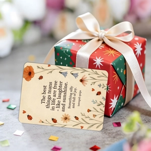 Detailansicht einer Deko-Geschenkkarte und roter Weihnachtsbox mit Seidenband