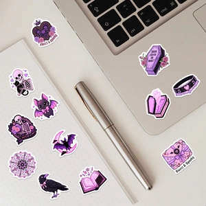 Detail of purple gothic stickers featuring sweet and spooky elements on a laptop