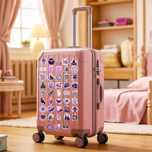 Gothic purple stickers applied on a pink suitcase featuring skulls and bats