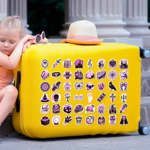 Close-up of cute purple pastel goth stickers decorated on a yellow travel suitcase
