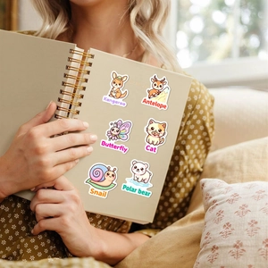 Dettaglio di adesivi di animali carini applicati su un quaderno ad anelli beige