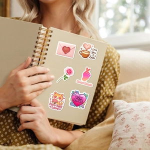 Nahaufnahme süßer Valentinstag-Sticker mit Katzen und Kaffee auf einem Notizbuch