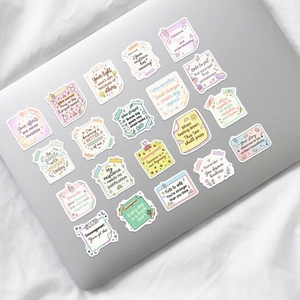 Macro shot of 20 waterproof motivational stickers on a laptop in pastel color aesthetic