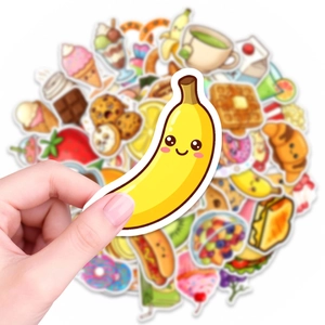 Close-up of a hand holding a cute yellow banana sticker from a 50pcs food sticker pack