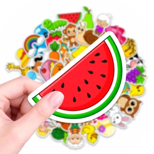 Close-up of a waterproof watermelon sticker held over a colorful cartoon sticker pack