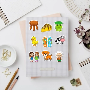 Flat lay of cute waterproof cartoon animal and character stickers on a grid notebook