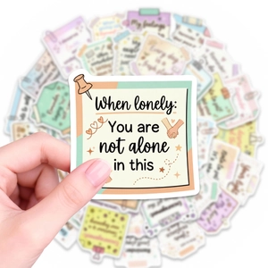 Close-up of motivational stickers with You Are Not Alone quote and hand-holding illustration