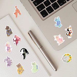 Cute cat stickers with floral patterns on laptop and journal for creative decoration