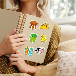 Close-up of cute waterproof cartoon stickers applied on a beige spiral notebook cover