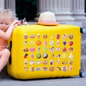 Close-up of cute food stickers on a yellow suitcase with kids travel accessories