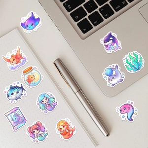 Detailed view of cute cartoon marine life stickers and mermaid decals on a white notebook
