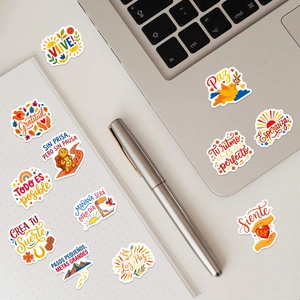 Detail of colorful Spanish motivational stickers applied on a laptop and notebook cover