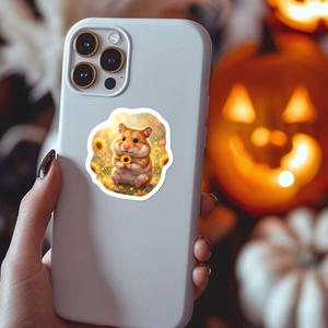 Nahaufnahme eines Hamster-Stickers mit Sonnenblume auf einer weißen Handyhülle