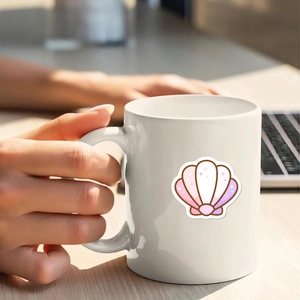 Nahaufnahme einer Hand, die eine weiße Tasse mit rosa Muschelmotiv im Büro hält