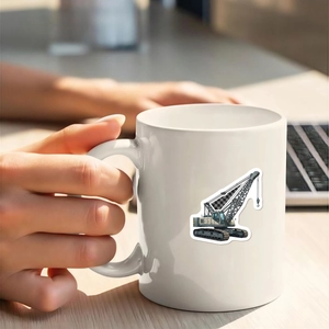 Close-up of hands holding a white ceramic mug with crane sticker and office background