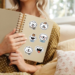 Detail of waterproof cartoon dog stickers with GIFT and SHY text on a notebook cover