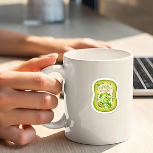 Detalle de una pegatina impermeable de helado de kiwi en una taza de cerámica blanca