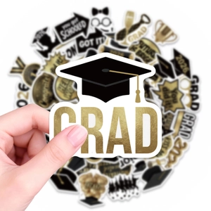 Detail of waterproof graduation stickers featuring gold GRAD text and black doctoral caps