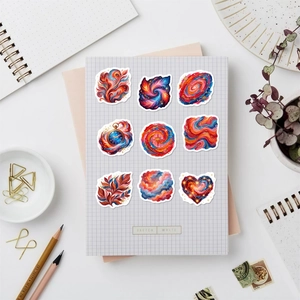 Detailansicht von neun bunten Nebula-Fluid-Art-Aufklebern auf einem Skizzenbuch