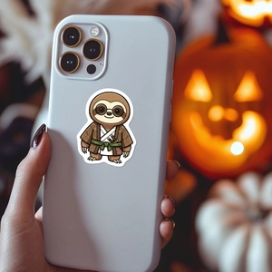Cute cartoon samurai sloth sticker shown on a smartphone back with festive background
