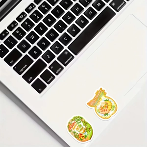 Detalle de pegatinas de frutas tropicales de melocotón y piña en un ordenador