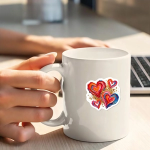 Bunter Nebel-Herzaufkleber auf einer weißen Keramiktasse in einer Lifestyle-Arbeitsumgebung