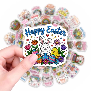 Close-up of hand holding a Happy Easter sticker with watercolor rabbit and egg motifs