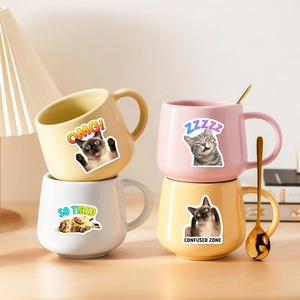 Charming cat expression ceramic mugs in pastel colors on a cozy wooden desktop setting