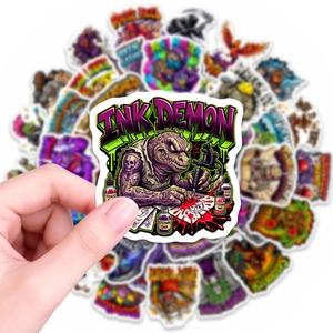 Detail of Ink Demon cartoon sticker held by hand showing waterproof vinyl texture