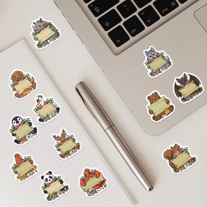 Close-up of cute cartoon animal stickers with blank wooden signs on a laptop and notebook