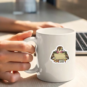 Close-up of a white ceramic mug featuring a cute forest eagle and blank wooden sign