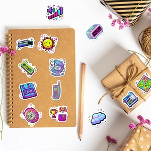 Close-up of retro Y2K pixel art stickers featuring game icons on a kraft notebook and box