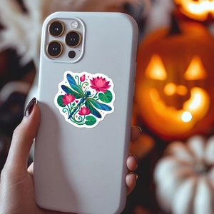 Ethnic dragonfly and lotus sticker applied on the back of a white smartphone case