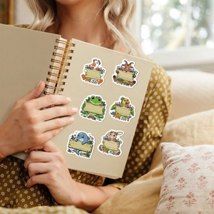 Close-up of cute cartoon animal stickers with blank wooden signs on a journal cover