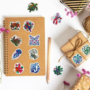 Detailed shot of ethnic animal stickers with mandala patterns on a craft notebook