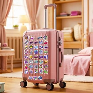 Close-up of retro pixel art stickers on a pink suitcase featuring vintage gaming icons