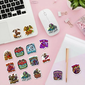 Close-up of waterproof cartoon monster stickers on a laptop and pink office desk setup