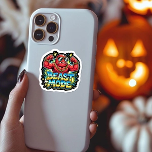 Beast Mode cartoon monster sticker applied on the back of a modern grey smartphone