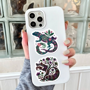Artistic tropical animal stickers on a matte white phone case with floral patterns