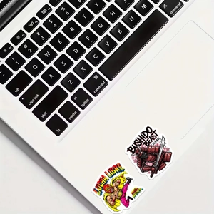 Waterproof vinyl stickers with samurai and wrestler designs on a laptop surface