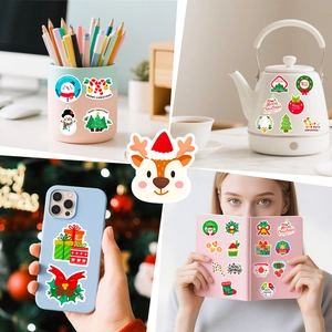 DIY Christmas stickers decorating phone case, mug, and stationary in festive red and green