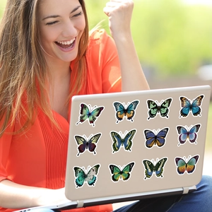 Levendige vlinderstickers aangebracht op een laptop in een lifestyle buitenomgeving