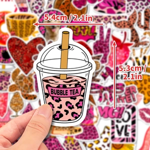 Dettaglio di un adesivo bubble tea leopardo rosa tenuto in mano per mostrare la texture