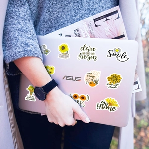Detail of sunflower motivational stickers on a laptop featuring Keep Life Simple text