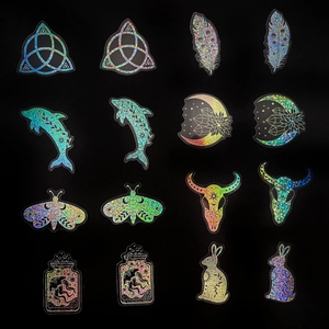 Holographic laser stickers featuring moon, skulls and moth motifs in a 4x4 matrix layout