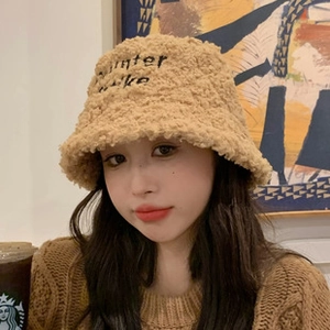 Detail of beige fleece bucket hat with winter make embroidery and fuzzy texture